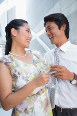Happy couple dressed up for a date having champagne