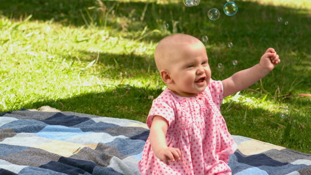 Baby girl playing with bubbles