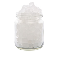 Rock sugar in a glass container over white background