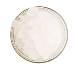 Rock sugar in a glass container over white background