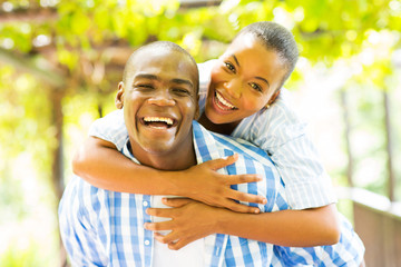 african woman enjoying piggyback ride on boyfriend