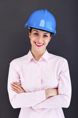 Woman architect, contractor in blue helmet over dark background