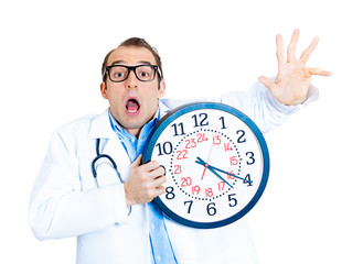 Tired, running out of time. Stressed doctor holding wall clock