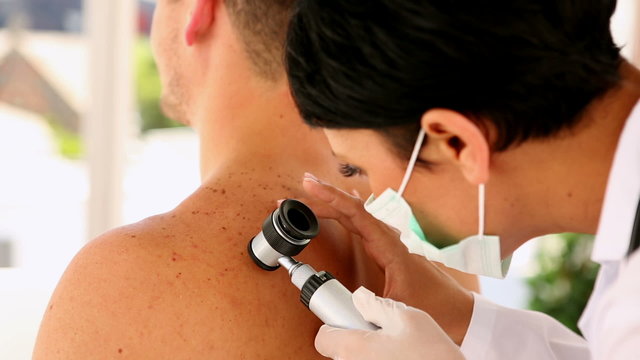 Man getting his mole checked by the dermatologist
