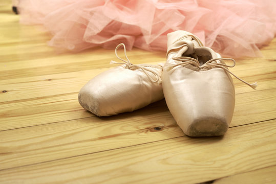 pair of ballet shoes pointes on wooden floor