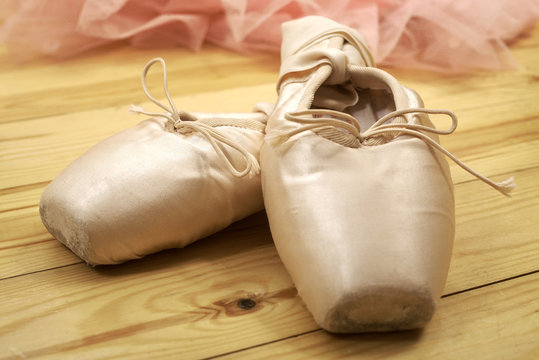 pair of ballet shoes pointes on wooden floor