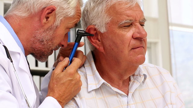 Doctor examining his patients ears