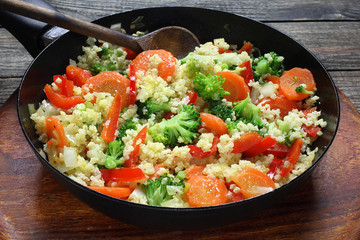 Millet fried with carrots, broccoli, paprika and onion