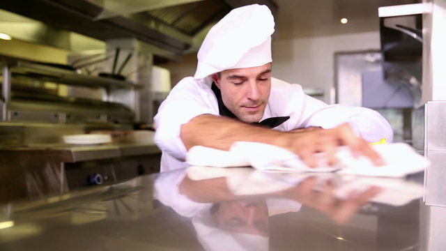 Handsome chef wiping down the counter