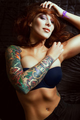 Beautiful girl with stylish make-up and tattooed arms: