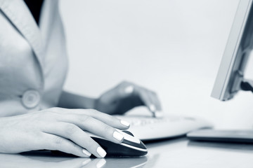 Female hand using computer mouse and keyboard