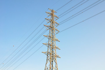 High voltage poles on blue sky background