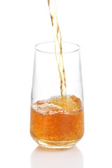 Juice pouring into glass isolated on white