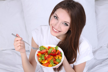 Young beautiful woman in bed with light breakfast