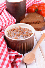 Boiled buckwheat with milk in bowl on table close-up