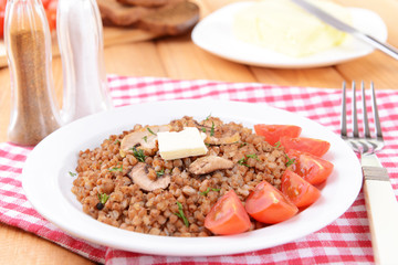 Boiled buckwheat on plate on table close-up