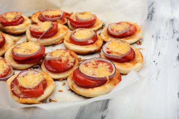 Small pizzas on baking paper close up