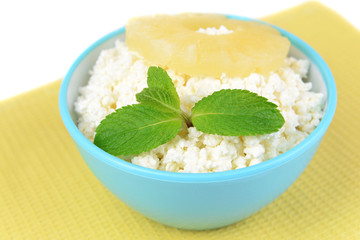 Bowl of tasty cottage cheese with pineapple, isolated on white