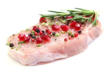 Raw meat steak with herbs, spices and pomegranate seeds,