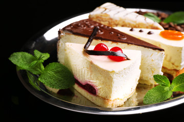 Assortment of pieces of cake, on dark background © Africa Studio