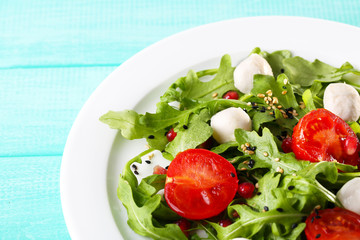 Fototapeta na wymiar Green salad made with arugula, tomatoes, cheese mozzarella