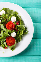 Green salad made with  arugula, tomatoes, cheese mozzarella