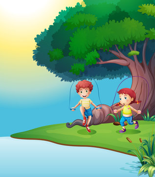 A boy and a girl playing near the giant tree