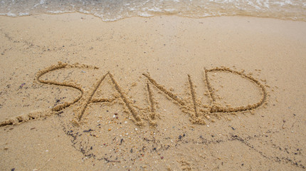 Beach with the word SAND written on the sand 