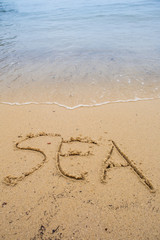 Beach with the word SEA written on the sand 