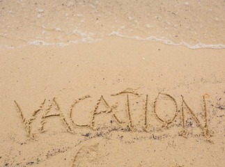 The VACATION word written on beach sand 