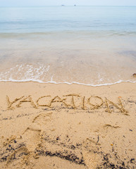 The VACATION word written on beach sand 