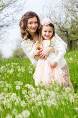 Mother and daughter in field with dandelions