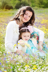 Mother and daughter in field with colorful flowers