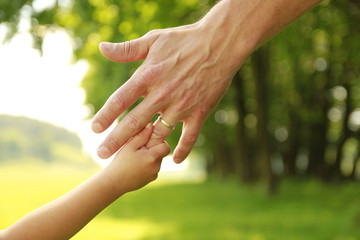 hand of parent and child in nature