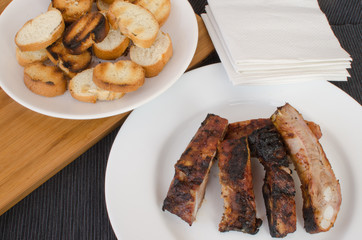 Spareribs on grill with dip and toasted baguette