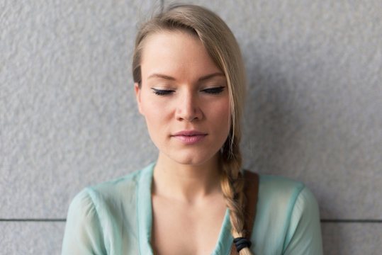 Intimate Blonde Woman Portrait With Closed Eyes Against Wall.