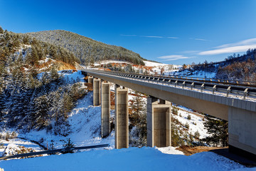 Mountain bridge in winter with snow and blue sky