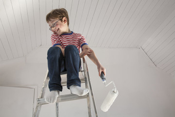 A boy seated on a stepladder.