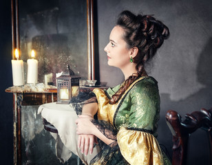 Beautiful woman in medieval dress near mirror