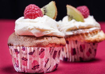 cupcakes with fresh fruits on the red and black background