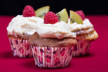 cupcakes with fresh fruits on the red and black background