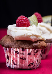 cupcakes with fresh fruits on the red and black background