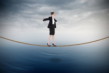 Composite image of businesswoman performing a balancing act