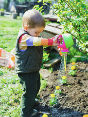 Трудолюбивый маленький мальчик работает в саду