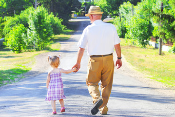 grandfather with his granddaughter are on the road