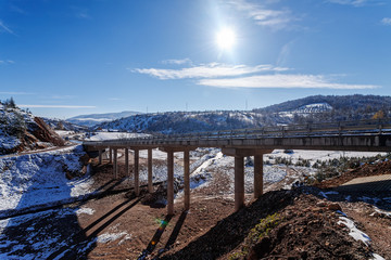 Mountain bridge in winter with snow and blue sky