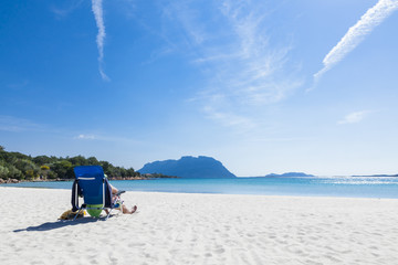 man relaxing at bright white beach