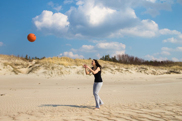 Girl playing beach basketball