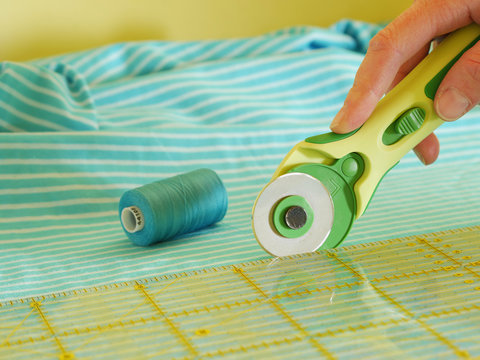 close up of cutting fabric with rotary cutter