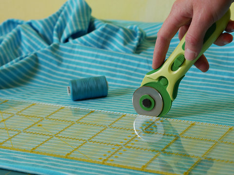 close up of cutting fabric with rotary cutter - Powered by Adobe
